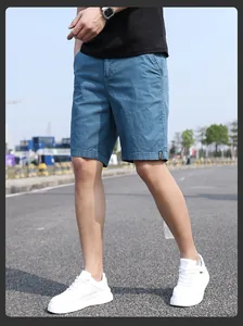 Outdoor street view of men's blue vintage Japanese-style loose work shorts with white sneakers