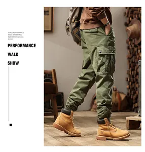 Man wearing green vintage multi-pocket cargo pants and boots in a retro studio setting