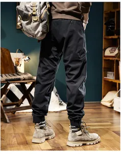 Rear view of men's black outdoor fleece-lined cargo pants with ribbed cuffs and side pockets.