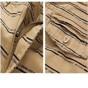 Close-up detail of khaki cotton cargo shorts featuring a metal zipper and buttoned pocket.