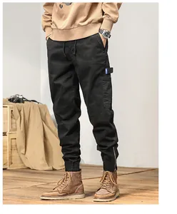 Macro view of black men's Japanese cargo joggers showing pocket detail and zipper ankle cuffs