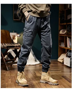 Close-up of men's dark grey cargo pants paired with tan boots in a vintage room