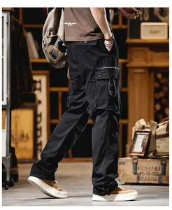 Close-up of black men's straight cargo pants in a rugged outdoor high street style