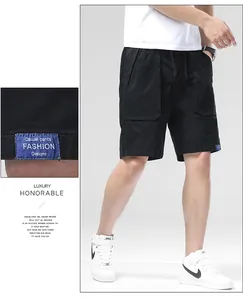 Detail of men's black cargo shorts showing the loose fit and blue woven fashion label tag