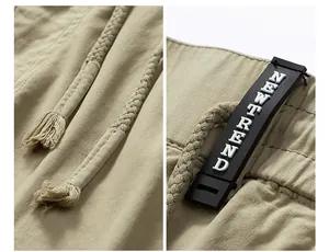 Close-up of drawstring and NEWTREND rubber label detail on khaki cargo pants