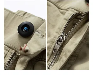 Close-up detail of metal zipper and black button on men's khaki cargo pants