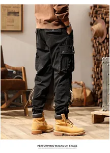 Detailed back view of men's black vintage multi-pocket cargo jogger pants in a rustic room