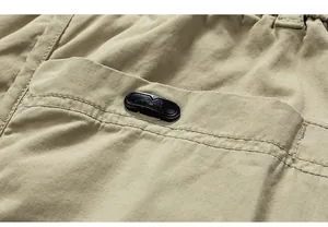 Close-up of the side pocket and decorative black tab on khaki cotton cargo pants