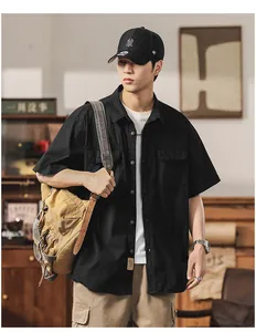Detailed view of a men's black short sleeve workwear shirt with dual chest pockets.