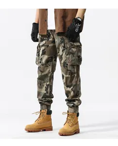Detail shot of men's camouflage cargo jogger pants with side pockets in a studio setting.