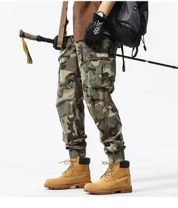 Detail view of men's camouflage cargo pants with multi-pocket design and tapered cuffs.