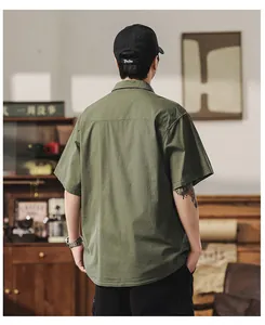 Detailed back view of men's army green cargo short sleeve shirt in a retro vintage room