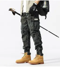 Full styling view of men's camouflage cargo pants paired with outdoor hiking boots and gear