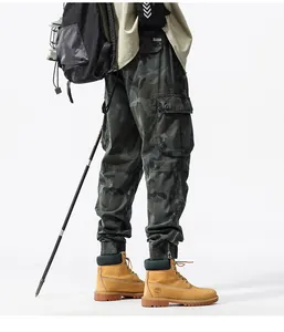 Detail view of men's camouflage cargo pants with utility pockets and jogger cuffs.