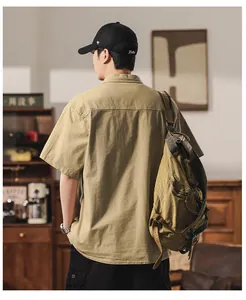 Detailed back view of a khaki short sleeve work shirt for men in a rustic cafe setting