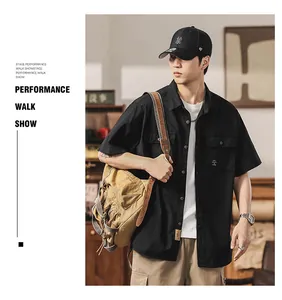 Professional model wearing a men's vintage black short-sleeved utility work shirt with pockets