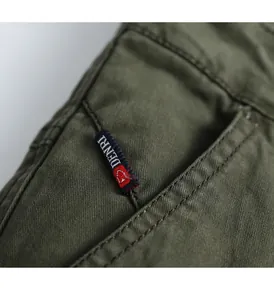 Macro detail of men's olive green cargo pants showing woven brand label and fabric texture