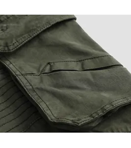 Close-up of olive green cargo pants side pocket detail showing durable twill fabric texture