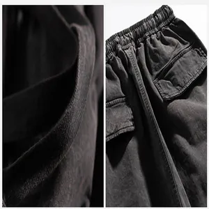 Detail view of washed grey techwear cargo pants with elastic waist and cargo pockets.