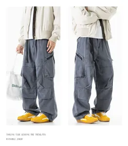 Close-up details of gray multi-pocket mountain style cargo pants showing loose straight fit