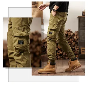 Detail view of men's olive green outdoor vintage cargo pants with multi-pocket jogger style