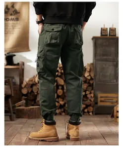 Back view of men's vintage dark green multi-pocket cargo pants in rustic setting