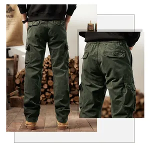 Back view of men's olive green cargo pants with multi-pocket details in a rustic setting.