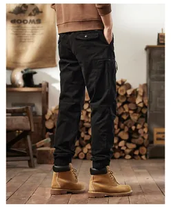 Rear view of black multi-pocket cargo pants with elastic jogger cuffs in rustic setting