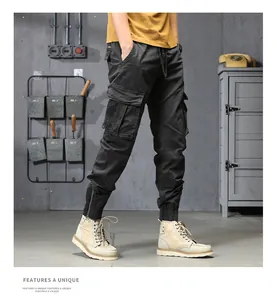 Detailansicht einer grauen Herren-Cargohose mit mehreren Taschen im Industriestil.