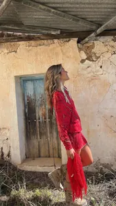 Detailed view of red tie-dye mini dress with long sleeves in a boho rustic setting