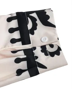 Close-up of shirt cuff featuring bold black and white floral print and a single white button.