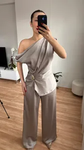 Detailansicht des eleganten champagnerfarbenen Satin-Sets mit One-Shoulder-Top und Hose