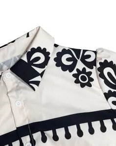 Detailed macro view of the black floral print and white buttons on a shirt dress collar