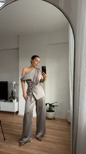 Detailansicht eines eleganten silbernen Satin-Sets mit drapiertem One-Shoulder-Top