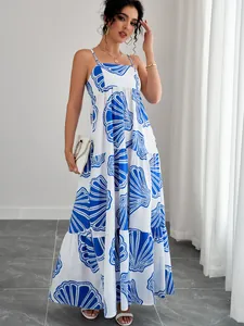 Detailansicht eines weißen Maxikleids mit blauen Muscheldrucken und Stufenrock