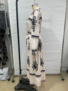 Detailed side view of cream long-sleeved maxi shirt dress with black ethnic prints