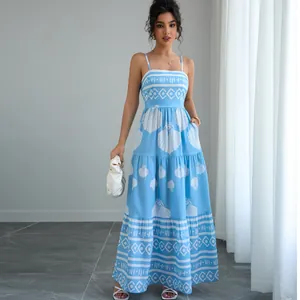 Detail of a light blue bohemian camisole maxi dress with shell and geometric prints.