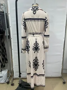 Back view of an elegant printed shirt maxi dress with black ethnic patterns on a mannequin.