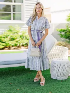 Bohemian floral V-neck maxi dress with purple waist belt and ruffle sleeves.