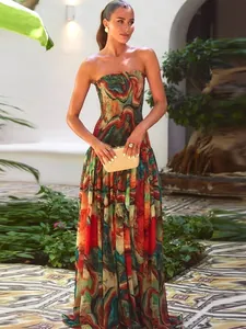 Elegant strapless maxi dress with colorful abstract print and flowing hem in a resort setting.
