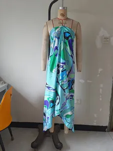 Detailed view of abstract print on a satin halter dress with an irregular hemline