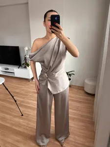 Elegantes champagnerfarbenes schulterfreies Oberteil und weite Hose im Set für Damen.