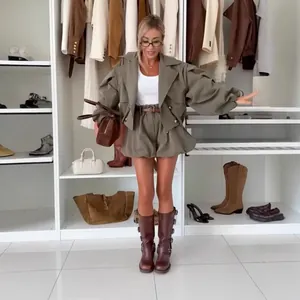 Modèle portant un ensemble deux pièces vert olive avec trench à manches bouffantes.