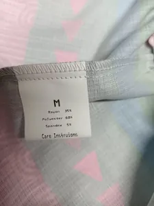 Close-up detail of the clothing care label showing size M and fabric composition