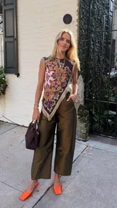 Elegante vintage mouwloze top met bloemenpatronen en details van franje-afwerking.