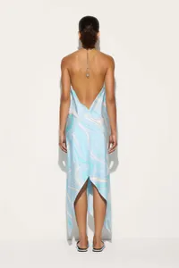 Back view of a satin halter maxi dress with blue swirl patterns and asymmetrical hem