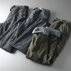 Detailed view of men's multi-pocket cargo pants in black and green with soft fleece lining