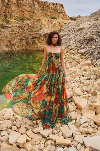 Detailed view of a vibrant printed tube top maxi dress in a scenic rocky quarry landscape.