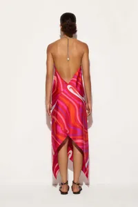 Back view of a vibrant satin halter maxi dress with irregular hem and psychedelic swirl print.