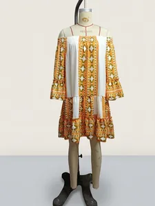 Off-the-shoulder bell sleeve tiered dress with yellow geometric pattern on mannequin
